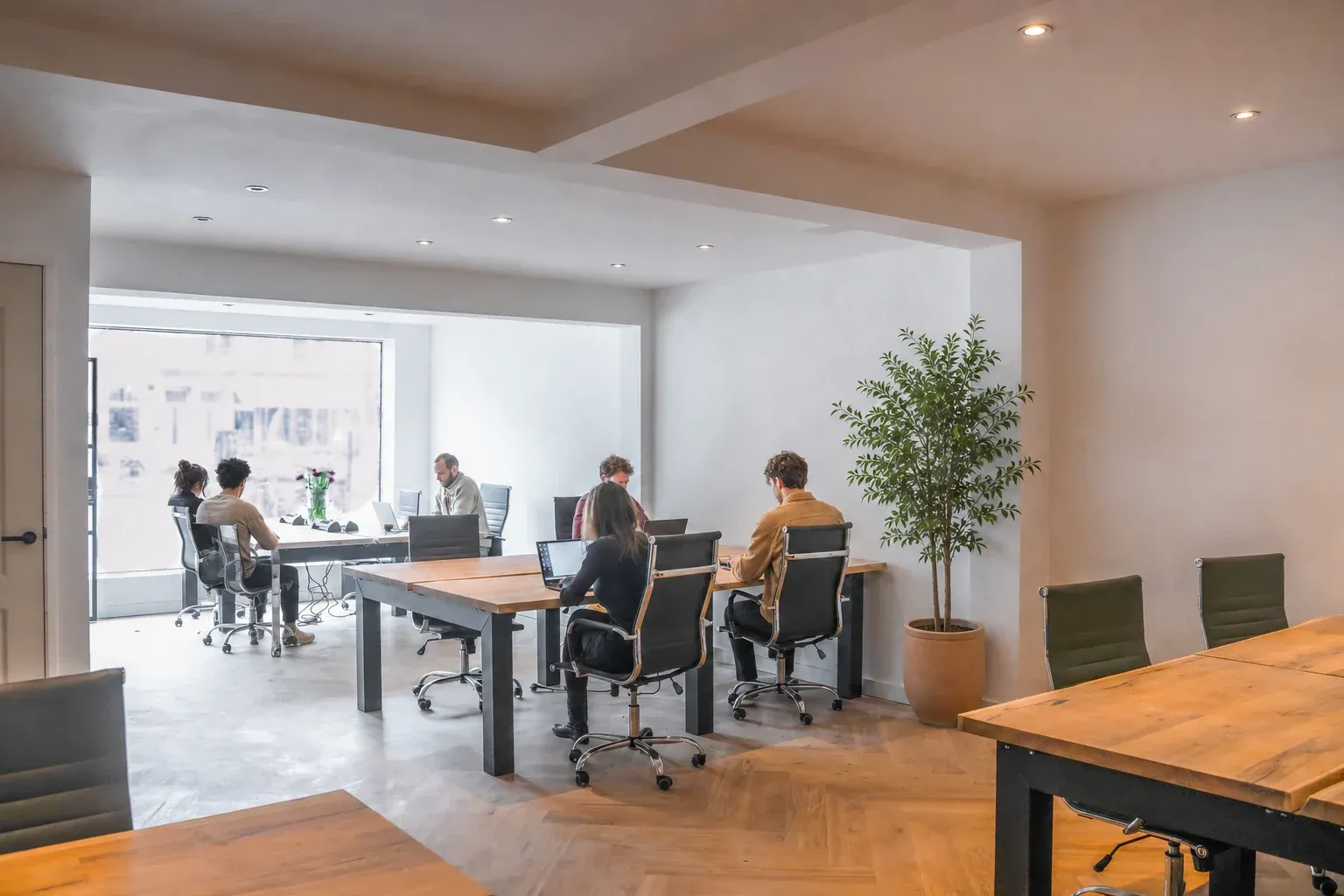 Vondel Desks members working in the bright workspace on Overtoom